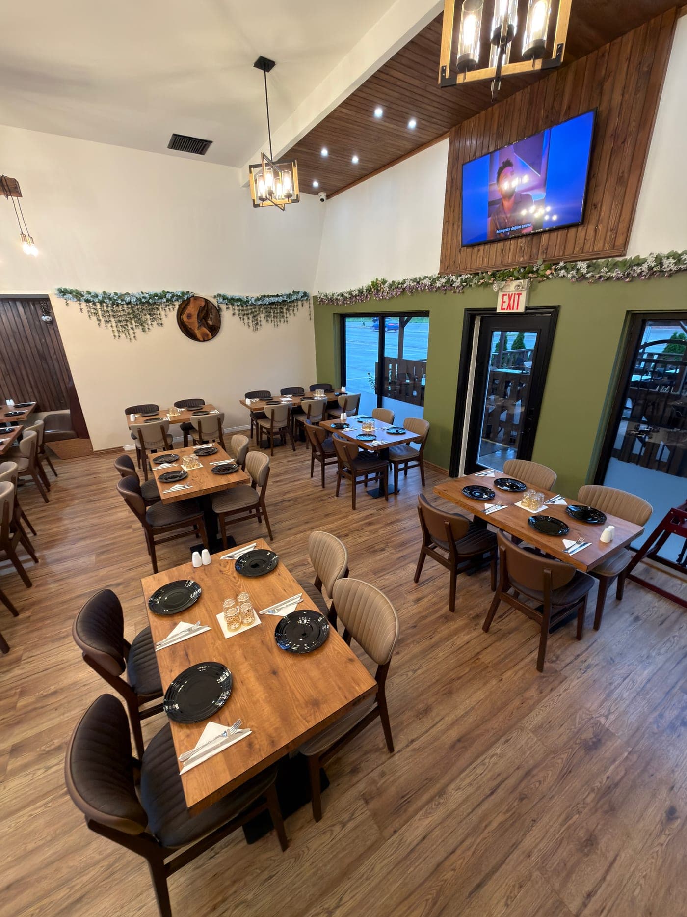 Iskender's dining room, with wooden tables set beneath warm pendant lighting